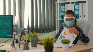 Yeni normal ofiste çalışan koruma maskeli bir yönetici