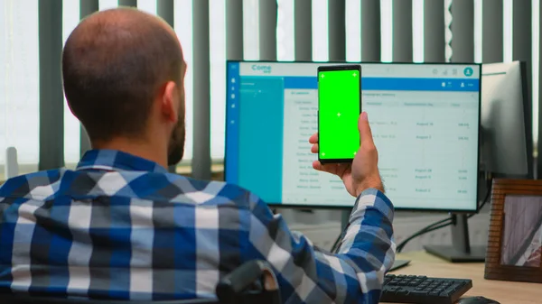 Obchodník na invalidním vozíku pomocí smartphonu se zelenou obrazovkou — Stock fotografie