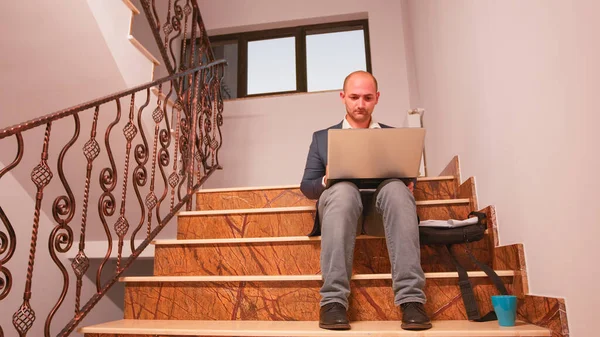 Gépelés laptop beszél telefonon ül a lépcsőn — Stock Fotó