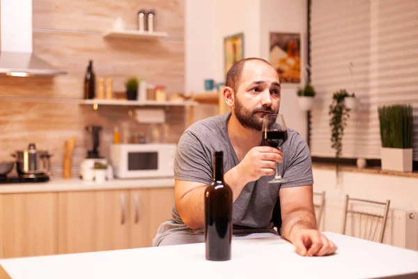 Man drinking alone at home