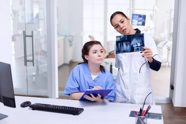 Dentist holding teeth x-ray explaning diagnosis — Stock Photo, Image
