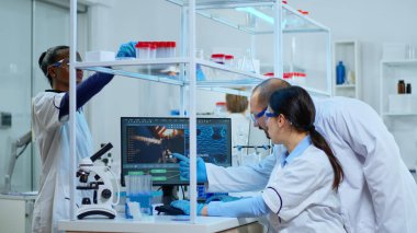 Mikrobiyoloji ekibinden bilim adamları virüs gelişimini tartışıyor.