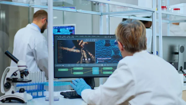 Medical research scientist typing codes on computer — Stock Photo, Image