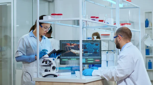 Scientist nurse taking notes on tablet in laboratory — Stock Photo, Image