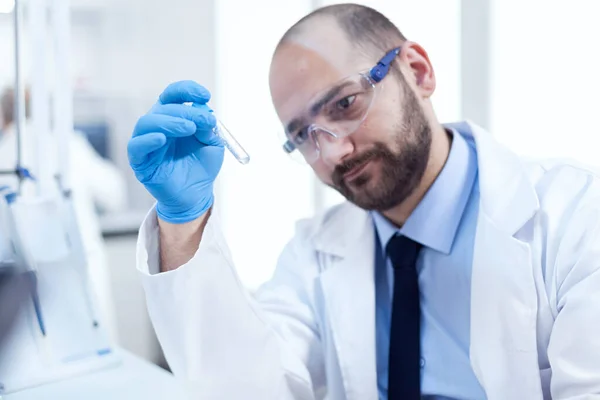 Доктор вчений у професійній лабораторії дивиться стогін на пробірці — стокове фото