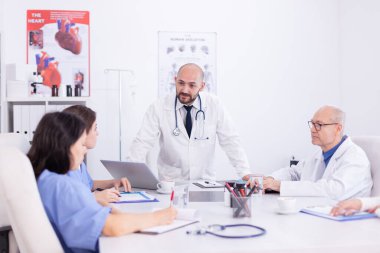 Doktor ayakta konuşuyor ve konuşuyor.