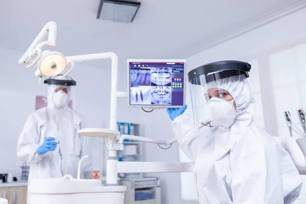 Точка зрения пациента у стоматолога в офисе, изучающего рентгенографию зубов на мониторе — стоковое фото