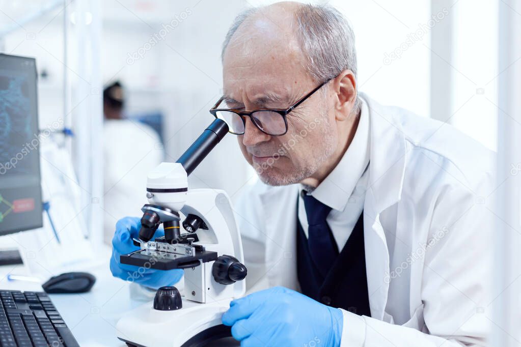 Senior scientist working on busy laboratory