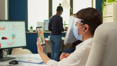 Girişimci maske takarak web kamerasında tartışıyor