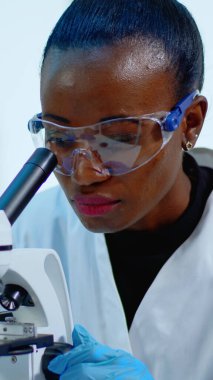 Mikroskop altında siyah bir kadına yakından bakın.