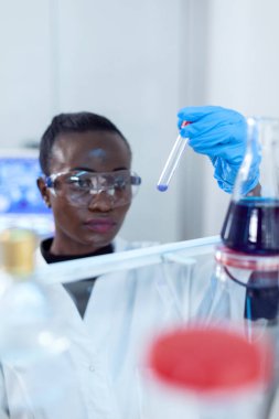 Kimyasal test tüplerinde mavi sıvıyla çalışan Afrikalı bilim adamı