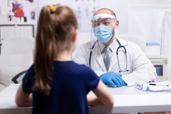 Doctor wearing visor during girl consultation — Stock Photo, Image