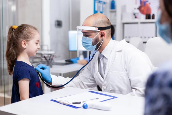 Pediatra słuchający serca — Zdjęcie stockowe