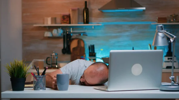 Hombre sobrecargado durmiendo en el escritorio de la cocina —  Fotos de Stock