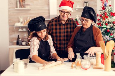 Deden Noel günü önlük giyip yeğenine yardım ediyor.