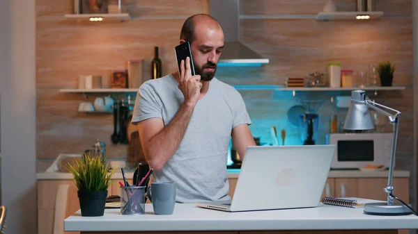 Trabajador remoto escribiendo en PC y hablando por teléfono —  Fotos de Stock