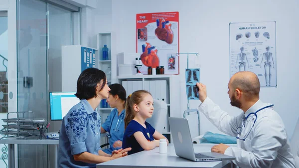 Γιατρός και ασθενείς που εξετάζουν ακτινογραφία — Φωτογραφία Αρχείου