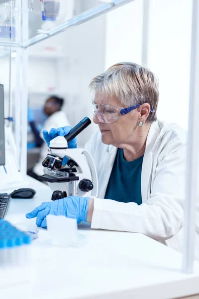 Donna scienziata anziana con occhiali protettivi che fa indagini genetiche — Foto Stock