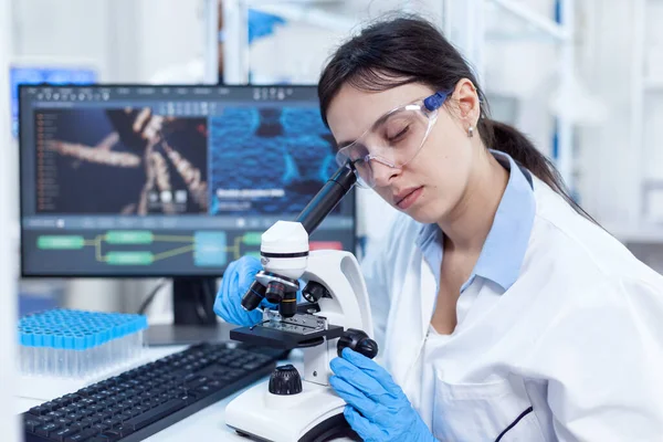 Female scientist in modern lab uses microscope — Stock Photo, Image