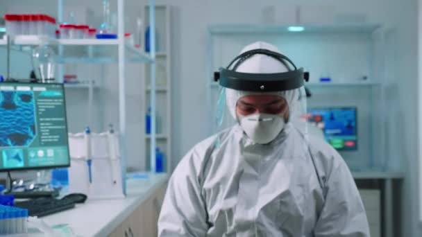 Portrait of tired scientist man in ppe suit looking at camera — Stock Video
