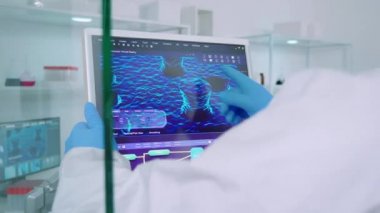 Kıyafetli kimyagerler aşı bileşimindeki değişiklikleri tartışıyorlar.