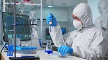 Pen giysisindeki kimyager test tüplerini doldurmak için mikropipet kullanıyor.