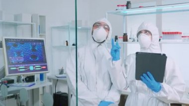 Kıyafetli bilim adamları kimya laboratuarında sanal gerçeklik kullanıyorlar.