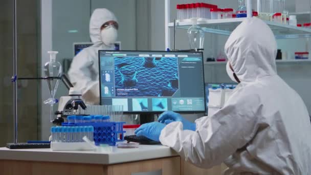 Científico médico en traje ppe trabajando con imagen de escaneo de ADN — Vídeos de Stock