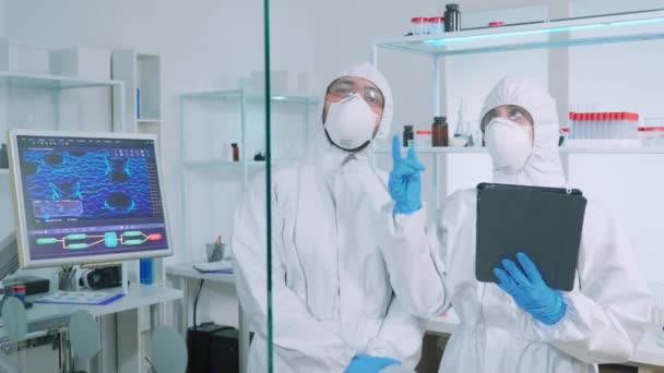 化学研究室での仮想現実を利用したパイプスーツを着た科学者チーム — ストック動画
