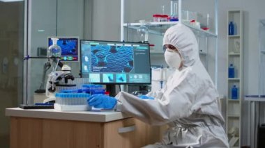 Teçhizatlı laboratuarda virüs testine bakan kimyager.