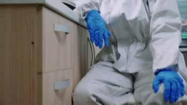 Takım elbiseli yorgun laboratuar doktoru kameraya bakıyor.