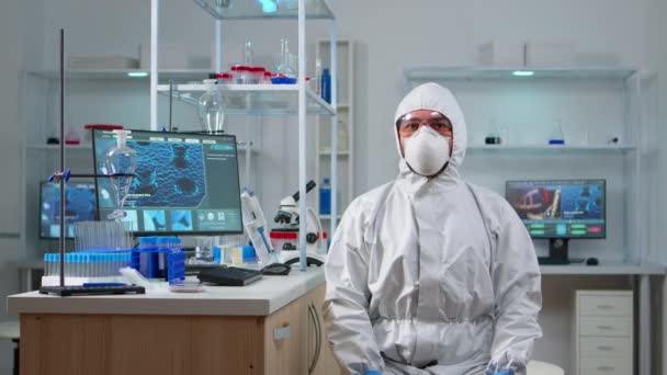 Technik laboratoryjny w kostiumie ppe pracujący z wirtualną rzeczywistością — Wideo stockowe