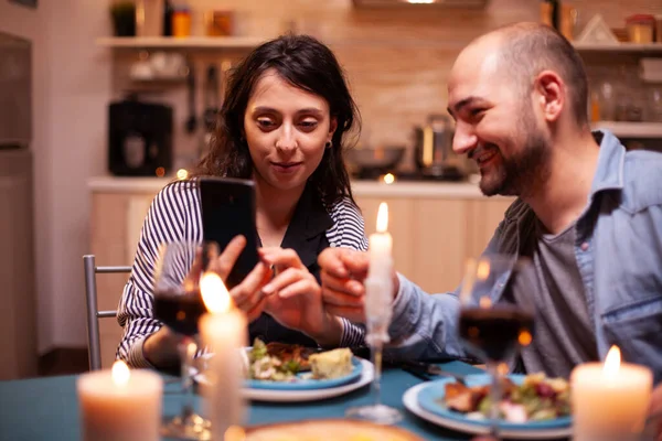 Coppia utilizzando il telefono durante la cena — Foto Stock