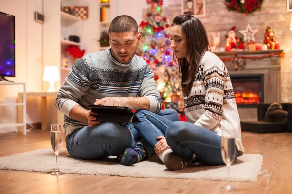 Pár v lásce sedí před vánoční stromeček — Stock fotografie