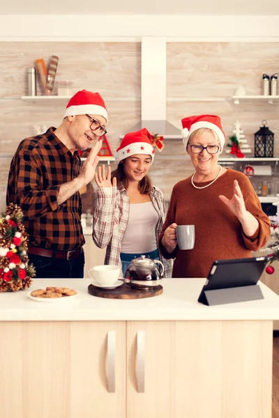 Fürsorgliches Enkelkind beim Weihnachtsgespräch mit Eltern am Tablet-PC. — Stockfoto