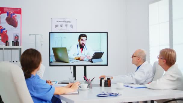 Tıbbi ekip toplantı odasında online konferans düzenliyor. — Stok video