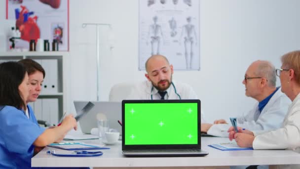Équipe de médecins utilisant un ordinateur portable avec écran vert devant la caméra — Video