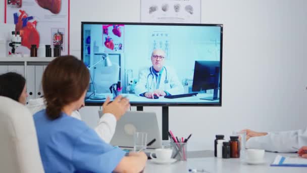 Skoncentrowany, celowo doświadczony zespół medyczny prowadzący internetowe spotkanie wideo — Wideo stockowe