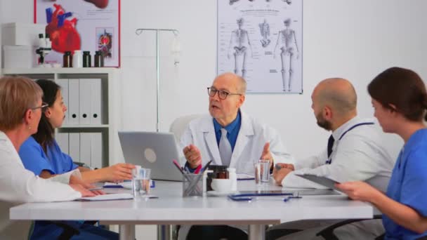 Medico specialista senior che spiega il trattamento ai colleghi — Video Stock