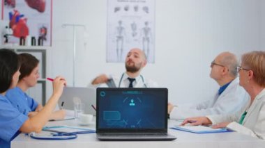 Muhtelif yaşlarda doktorlardan oluşan bir ekip masa başında beyin fırtınası yapıyor.