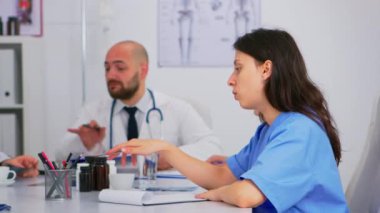 Doktorlar ve hemşireler toplantı odasında tıbbı tartışıyorlar.