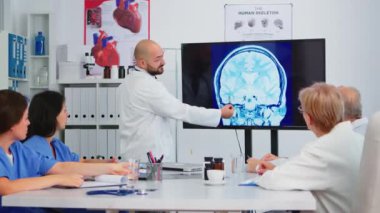 Tıbbi ekiple dijital röntgen görüntüsünün sonuçlarını analiz eden deneyimli bir doktor.