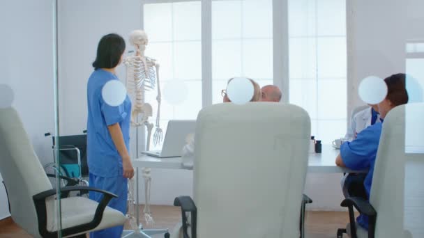 Medical nurse pointing on cervical spine of human skeleton — Stock Video