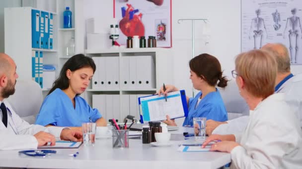 Equipe de médicos sentados em conferência sala de escritório do hospital discutindo — Vídeo de Stock