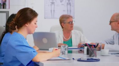 Beyin fırtınası sırasında hasta listesini kontrol eden hemşire.