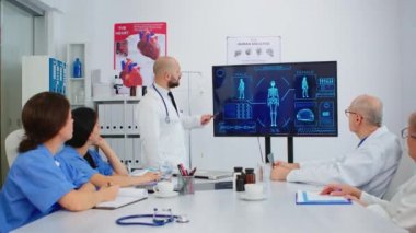 Doktor, dijital monitör kullanarak meslektaşlarına insan iç yapısını sunuyor.