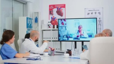 Profesyonel takım çalışanları öğretici tıbbi videolar izliyor.