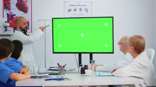 Medico che spiega gli argomenti della riunione in anteprima su un monitor a schermo verde — Video Stock