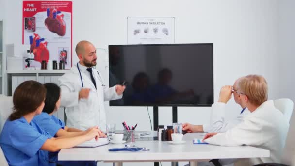 Orvosok csoportja, akik digitális röntgent analizálnak ötletelés közben — Stock videók