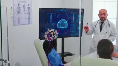 Tıp personeliyle konferans sırasında beyin aktivitesinden bahseden bir doktor.